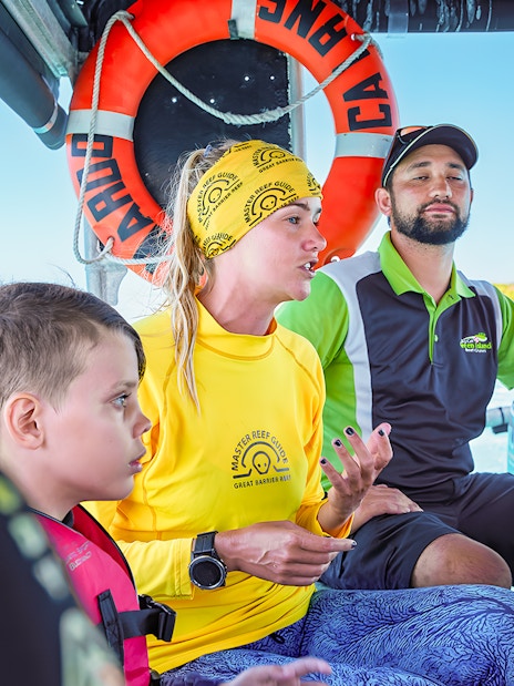 Tour guide explaining snorkeling options on a boat from Cairns to Green Island.