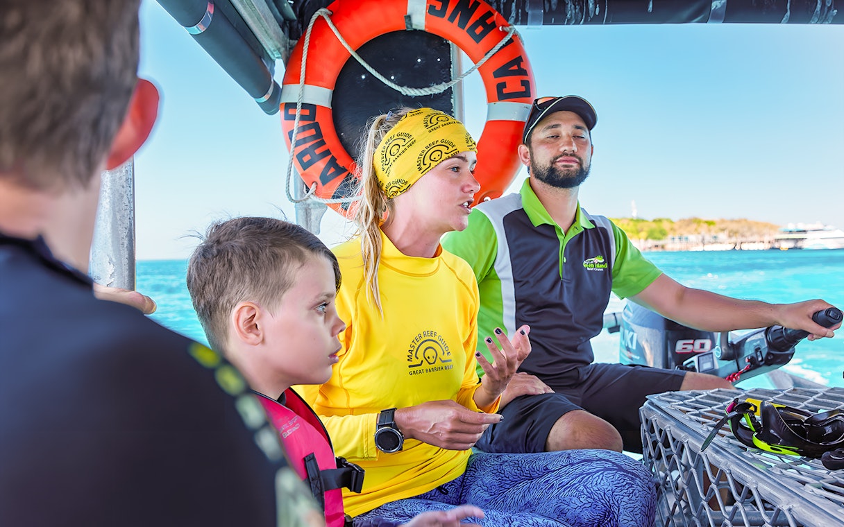 Tour guide explaining snorkeling options on a boat from Cairns to Green Island.