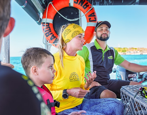 Tour guide explaining snorkeling options on a boat from Cairns to Green Island.