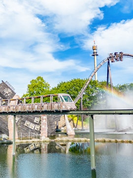 Roller coaster and monorail at Heide Park Resort with water feature and tower in background.