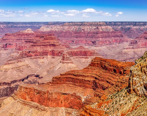Group of tourists enjoying the breathtaking view of the Grand Canyon South Rim during a guided tour