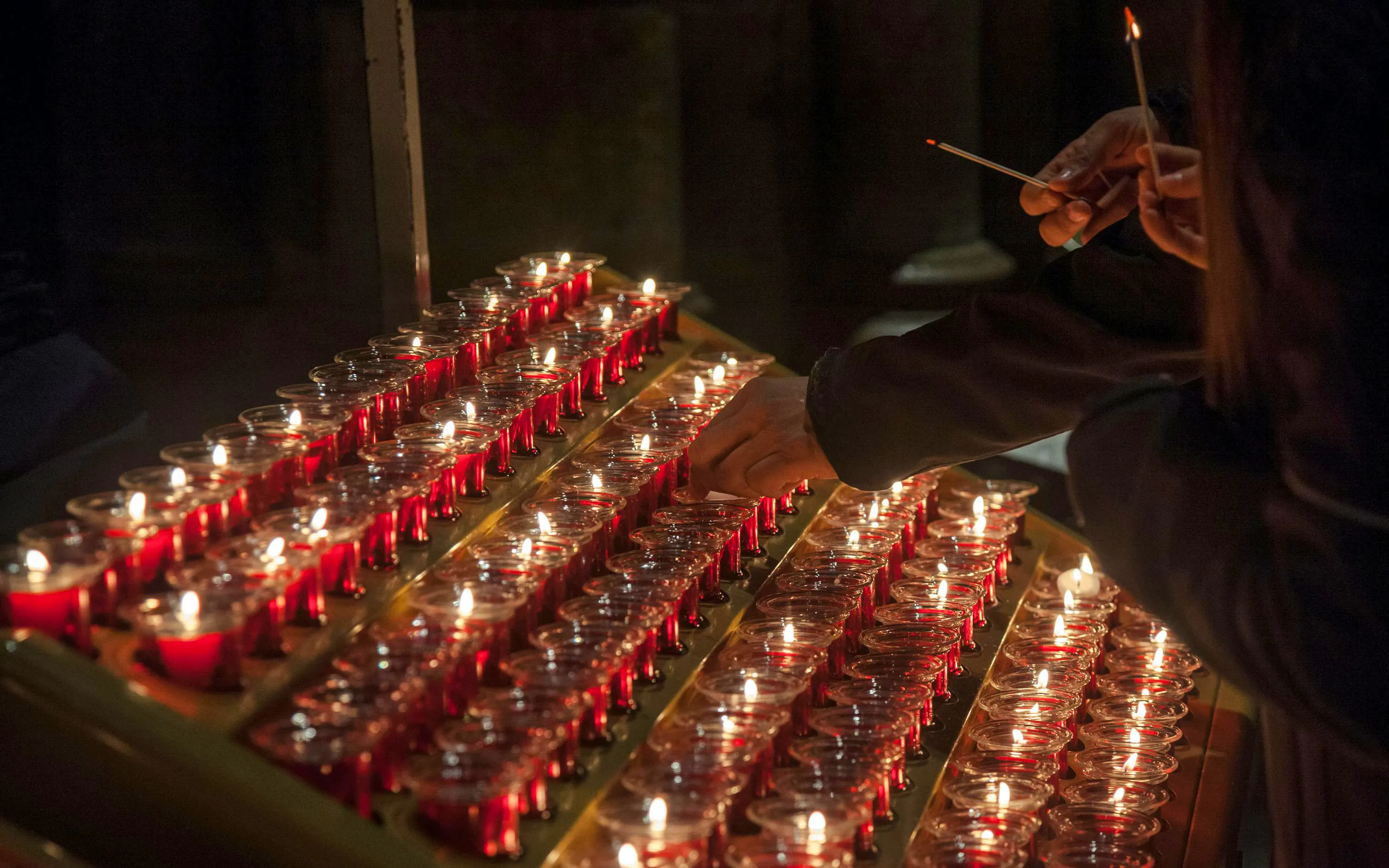 Lighting candles inside Notre Dame Cathedral, Paris, France.