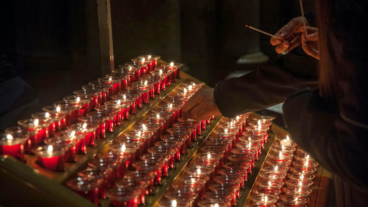 Lighting candles inside Notre Dame Cathedral, Paris, France.