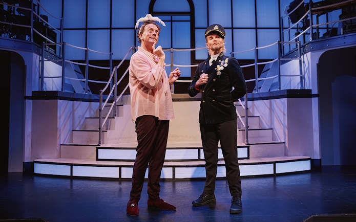 Actors performing on stage in a scene from the musical "Titanique.