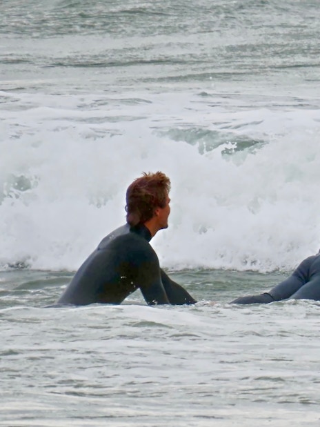 Surfers preparing to catch waves at a beach in Cascais.
