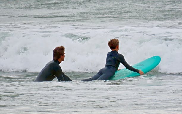 Surfers preparing to catch waves at a beach in Cascais.