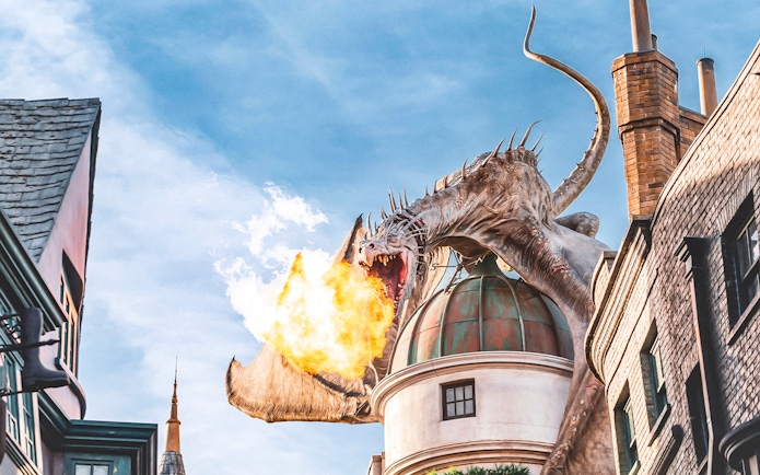Dragon breathing fire atop a building at Universal Studios Orlando Resort.