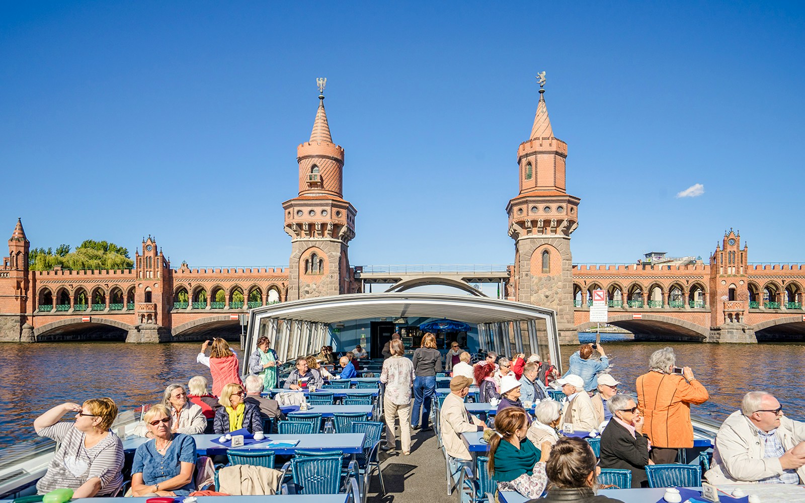 Guests on a boat tour viewing the Oberbaum Bridge in Berlin.