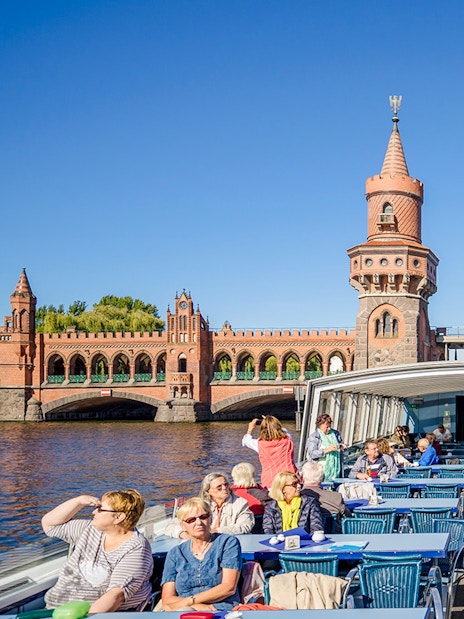 Guests on a boat tour viewing the Oberbaum Bridge in Berlin.