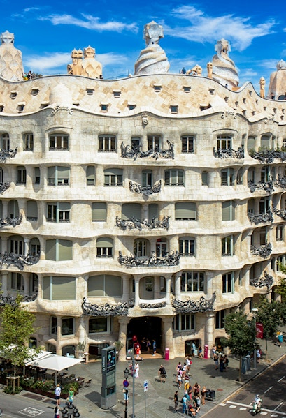 La Pedrera - Casa Milà in Barcelona, showcasing its unique stone facade and rooftop sculptures.