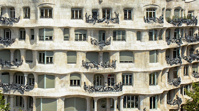 La Pedrera - Casa Milà in Barcelona, showcasing its unique stone facade and rooftop sculptures.