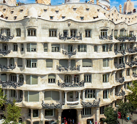 La Pedrera - Casa Milà in Barcelona, showcasing its unique stone facade and rooftop sculptures.