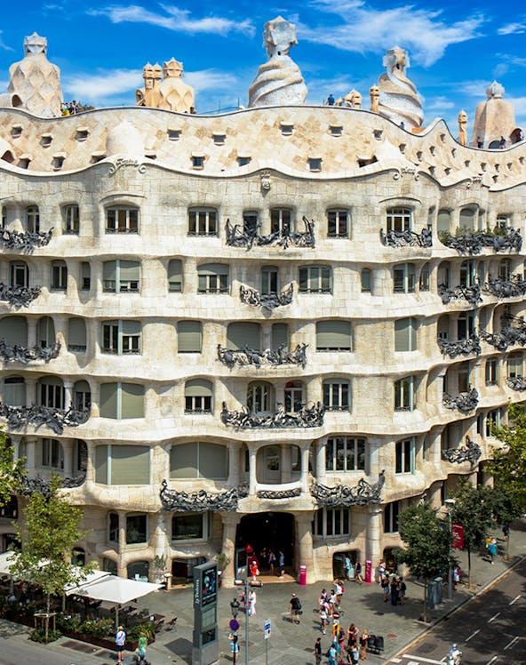 La Pedrera - Casa Milà in Barcelona, showcasing its unique stone facade and rooftop sculptures.