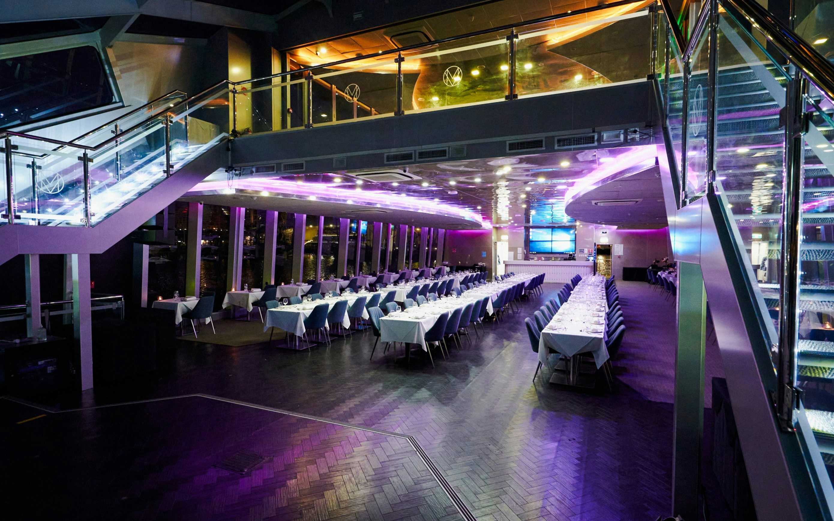 Elegant dining area on a Sydney dinner cruise ship with set tables and ambient lighting.