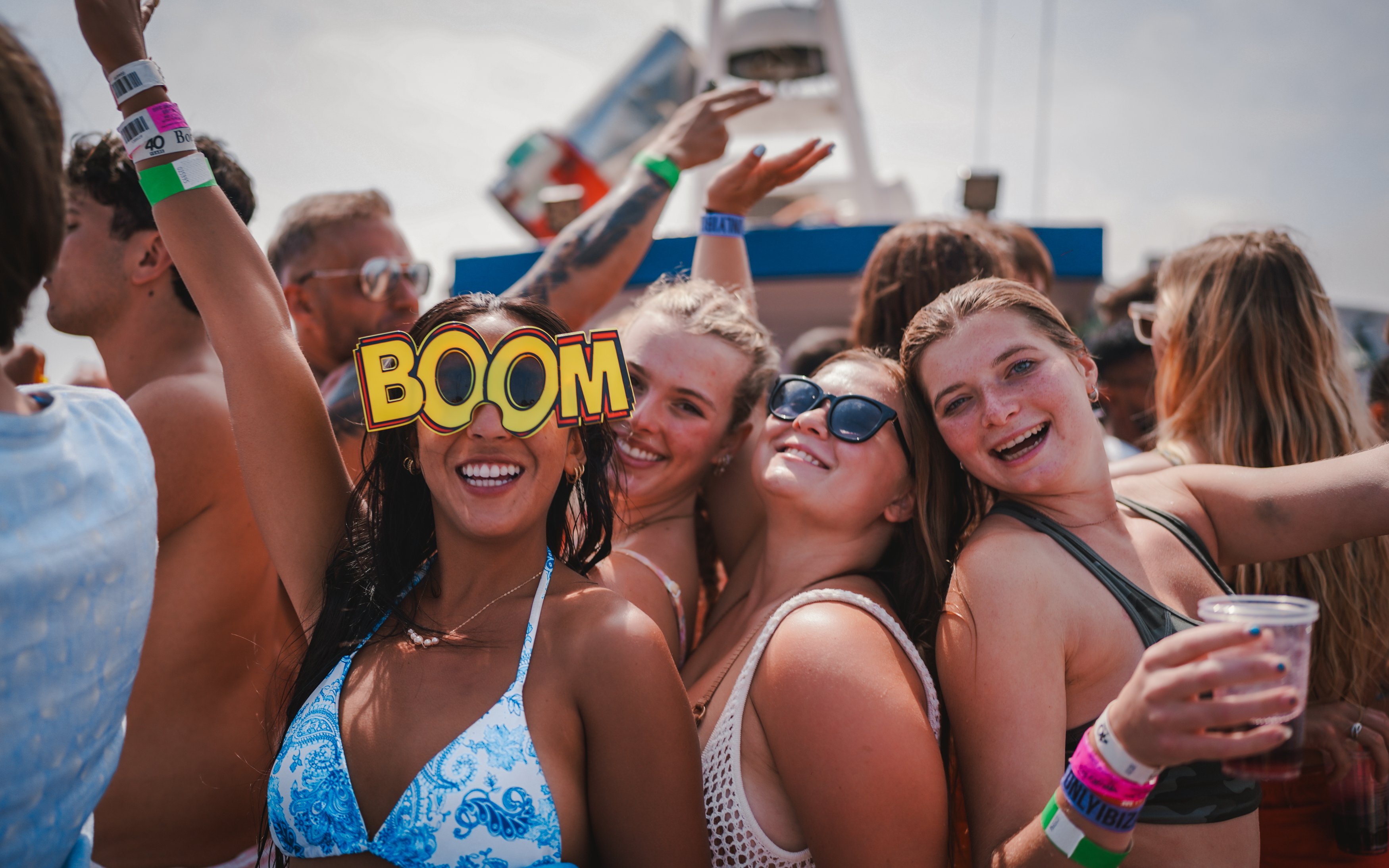 Tourists enjoying Cruise Crush Boat Party with drinks and festive atmosphere.