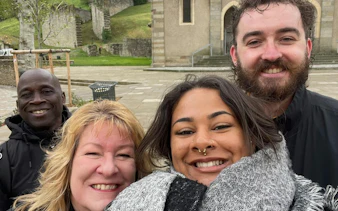Group of people smiling in front of a historic building in Carcassonne during a self-guided city exploration game.