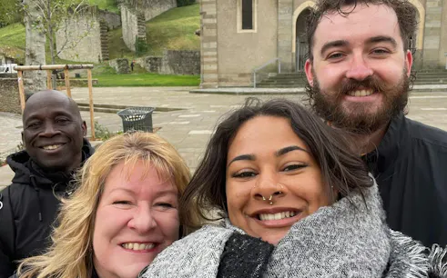 Group of people smiling in front of a historic building in Carcassonne during a self-guided city exploration game.