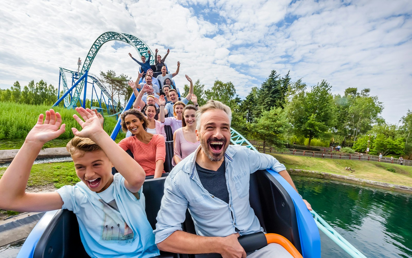 Parc Astérix roller coaster ride in Paris, France, with excited visitors.