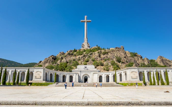 Valley of the Fallen monument with large cross and surrounding colonnade in Spain.