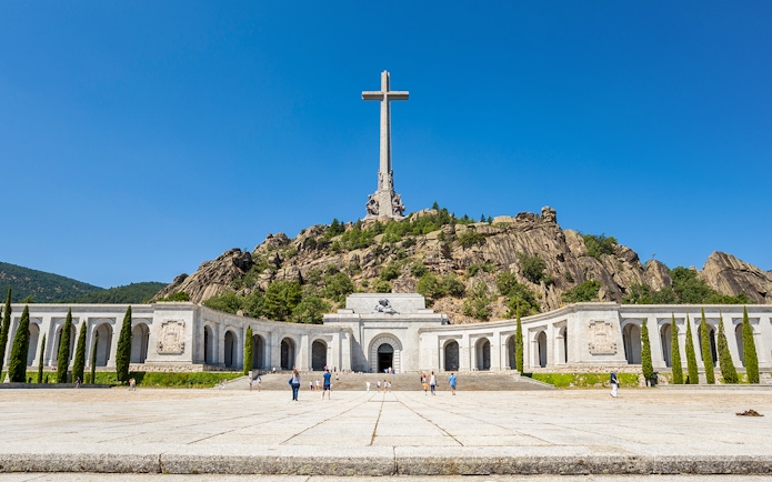 Valley of the Fallen monument with large cross and surrounding colonnade in Spain.