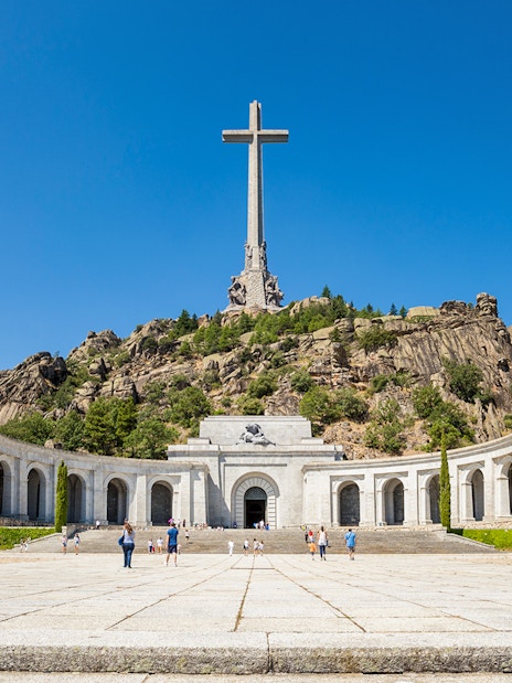 Valley of the Fallen monument with large cross and surrounding colonnade in Spain.