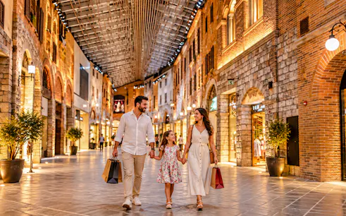Family shopping in a Dubai mall with expert guide on private car tour.