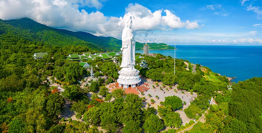 Lady Buddha statue on Son Tra Peninsula, Da Nang, Vietnam, surrounded by lush greenery and ocean views.