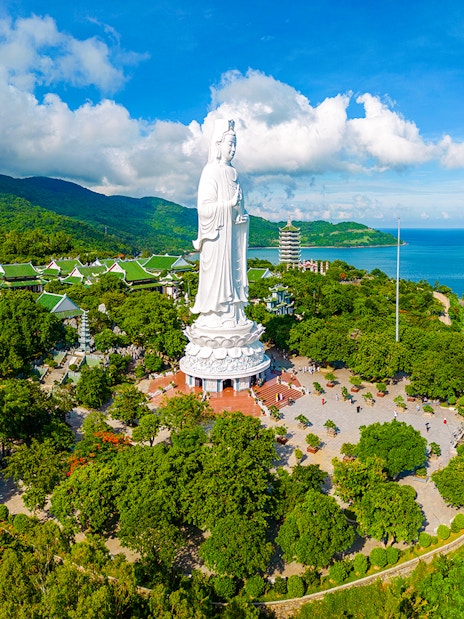 Lady Buddha statue on Son Tra Peninsula, Da Nang, Vietnam, surrounded by lush greenery and ocean views.