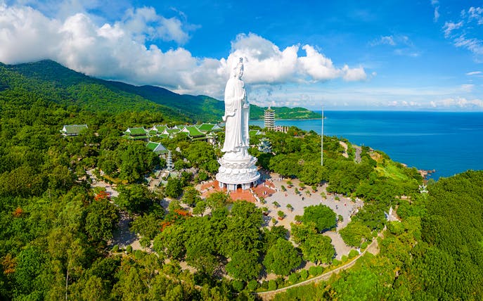 Lady Buddha statue on Son Tra Peninsula, Da Nang, Vietnam, surrounded by lush greenery and ocean views.