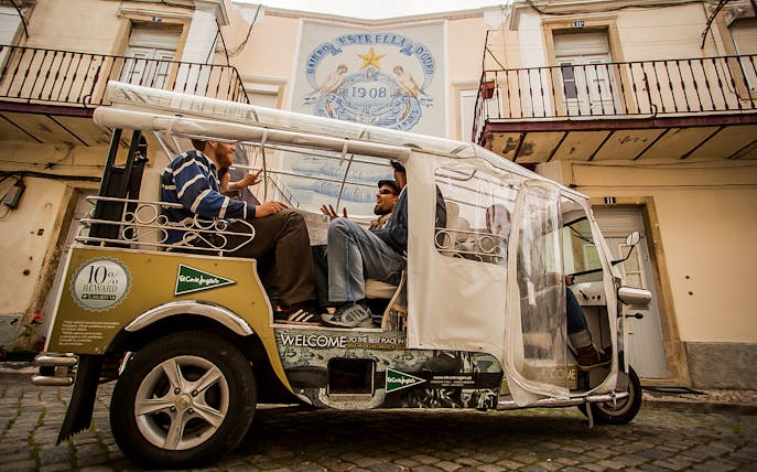 Private electric tuk tuk on cobblestone street during half-day guided sightseeing tour.