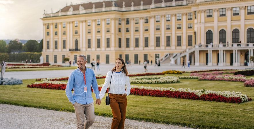 Couple walking in gardens of Schönbrunn Palace, Vienna.