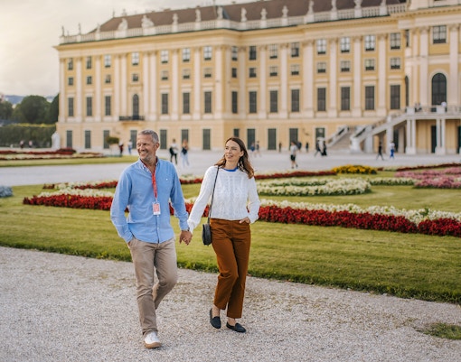 Couple walking in gardens of Schönbrunn Palace, Vienna.