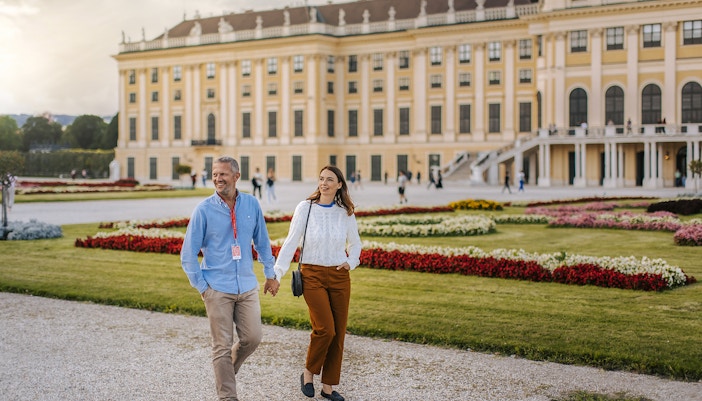 Couple walking in gardens of Schönbrunn Palace, Vienna.