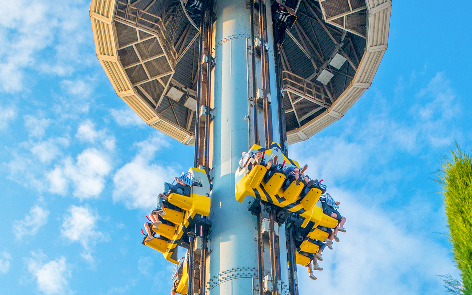 Riders on Space Vertigo drop tower at Gardaland, Verona against blue sky.