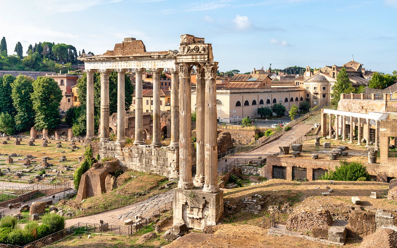 Roman Forum ruins with ancient columns and surrounding landscape in Rome, Italy.