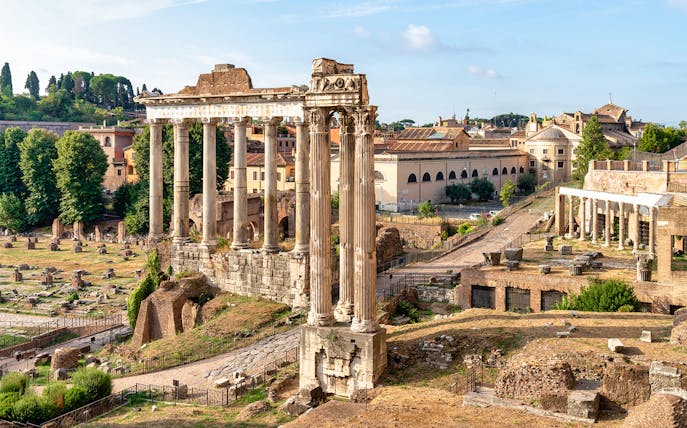 Roman Forum ruins with ancient columns and surrounding landscape in Rome, Italy.