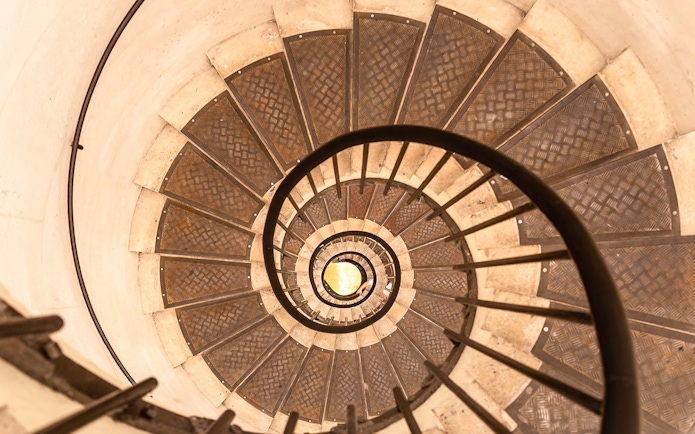 Spiral staircase view from above, showcasing intricate metal steps.
