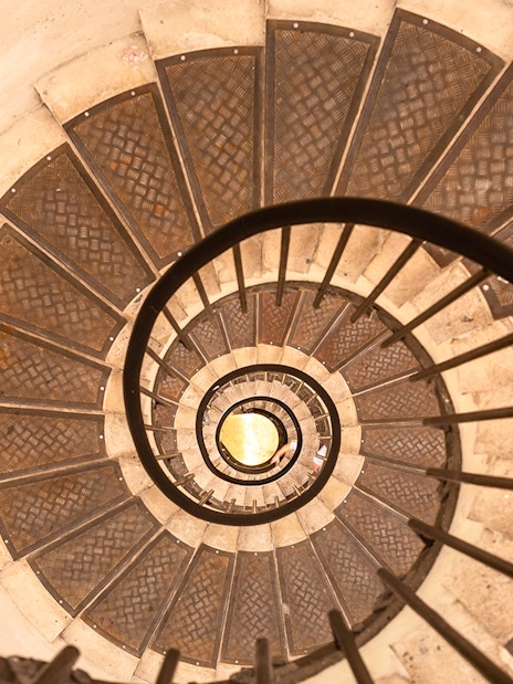 Spiral staircase view from above, showcasing intricate metal steps.