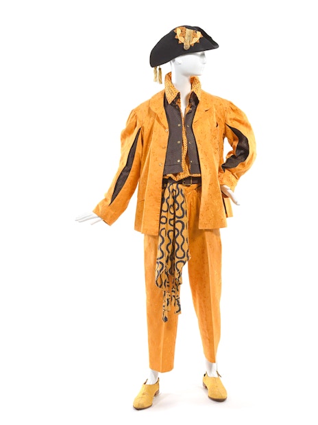 Mannequin in orange Vivienne Westwood outfit with hat at NGV exhibition.