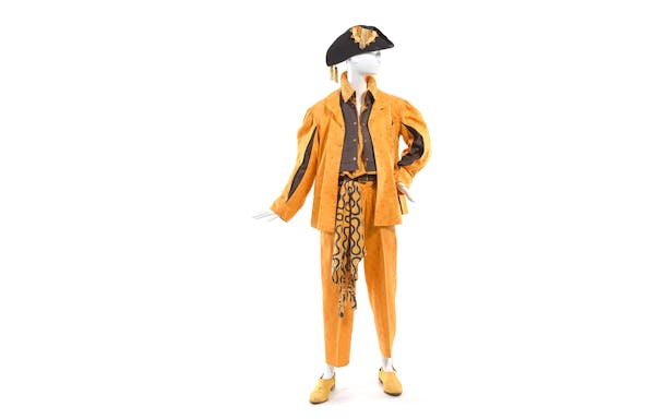 Mannequin in orange Vivienne Westwood outfit with hat at NGV exhibition.