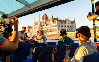 Sightseeing guests on Budapest Sunset Cruise with view of Hungarian Parliament.