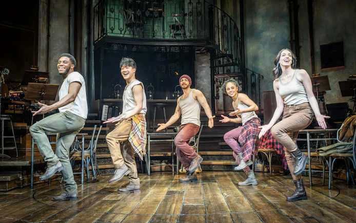 Performers dancing on stage during Hadestown show in West End theater.