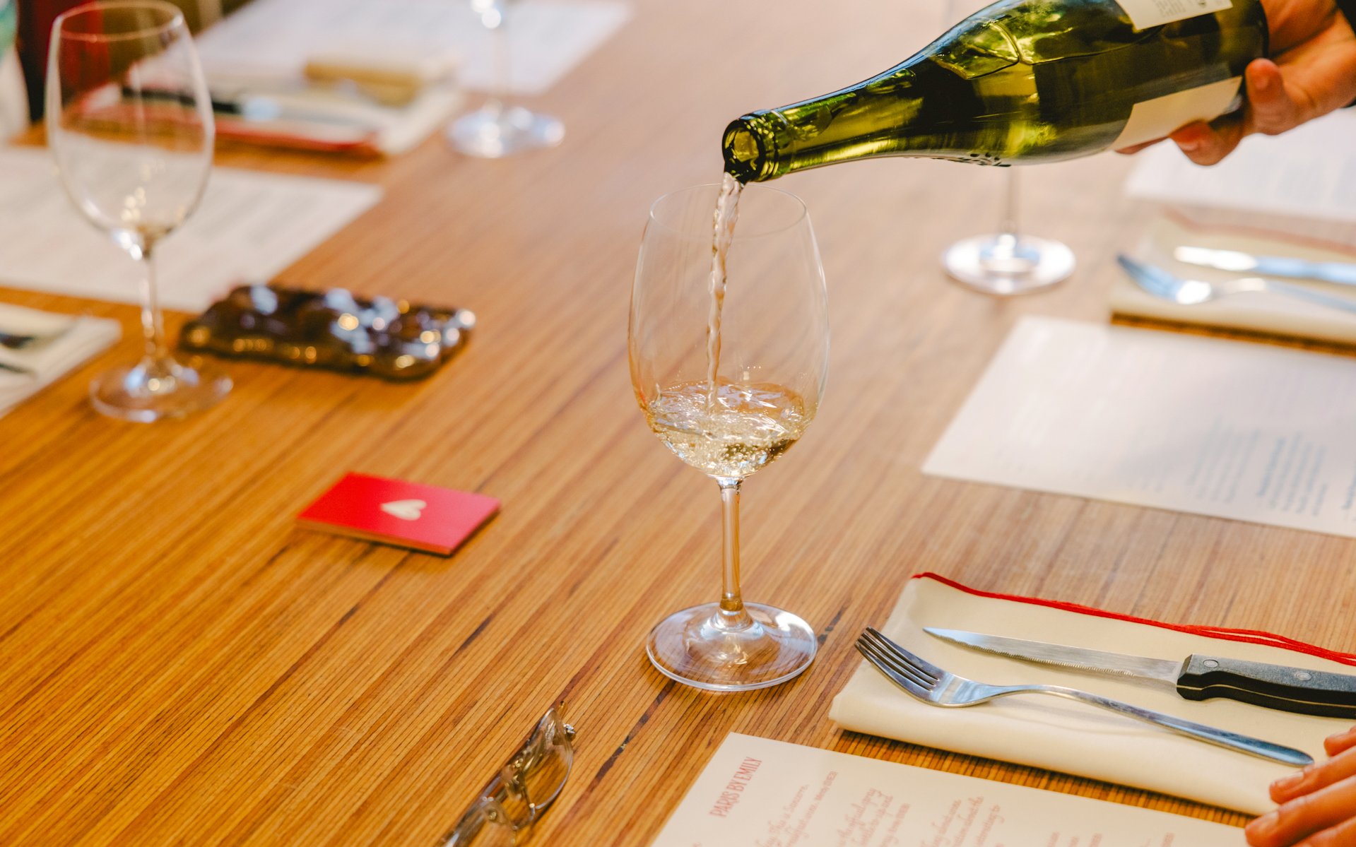 Pouring wine at a table during Emily in Paris tour, Paris, France.