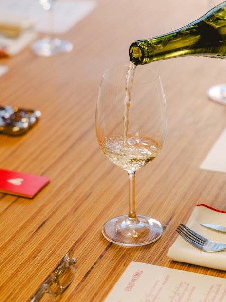 Pouring wine at a table during Emily in Paris tour, Paris, France.