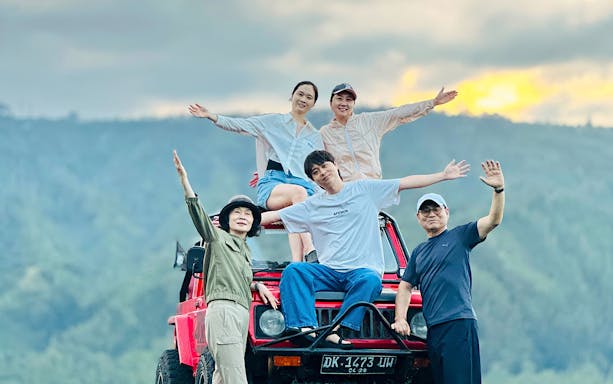 Group enjoying Kintamani sunset on a red 4WD jeep tour.