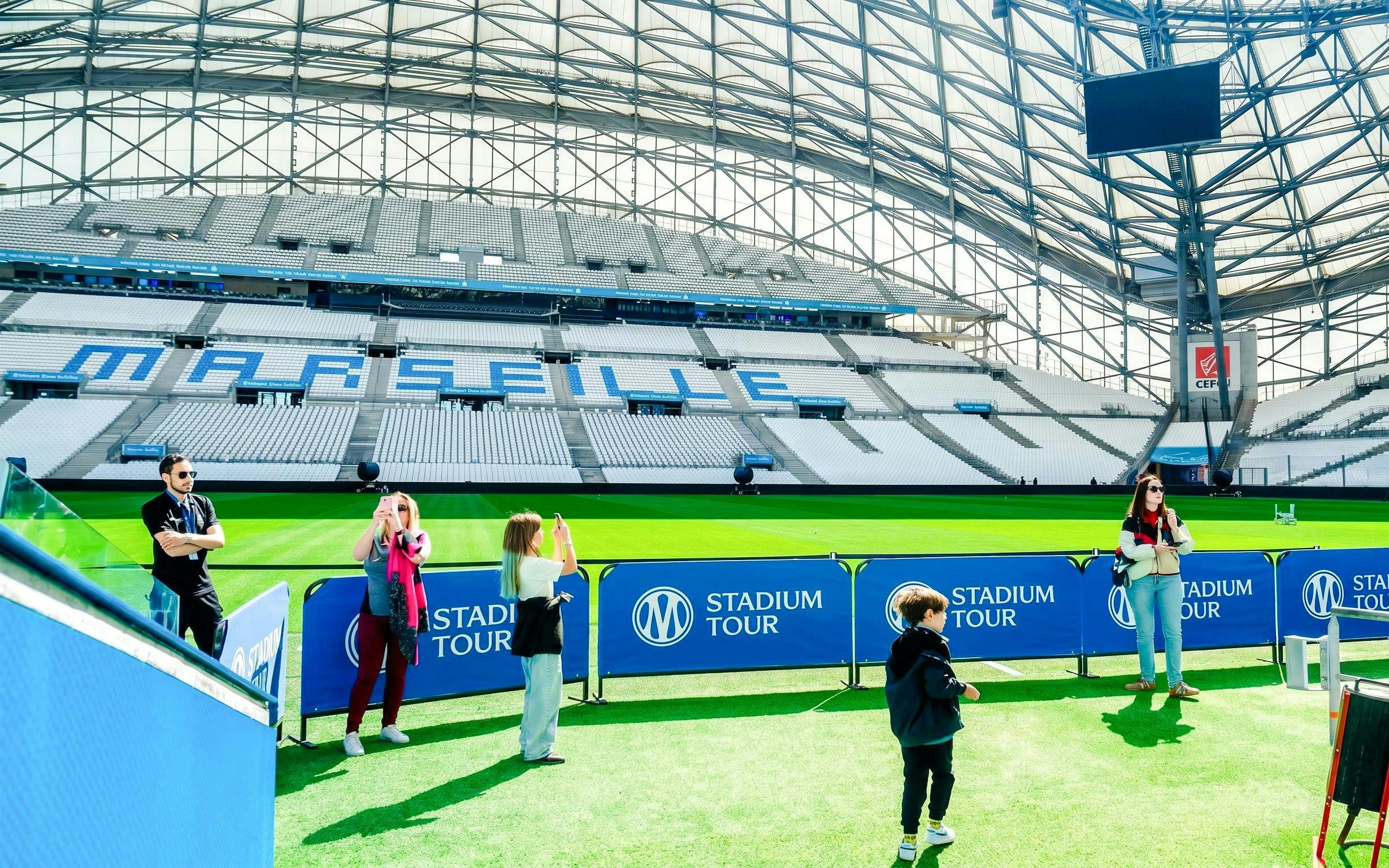 Visitors taking photos at OM Stadium in Marseille during a guided tour.