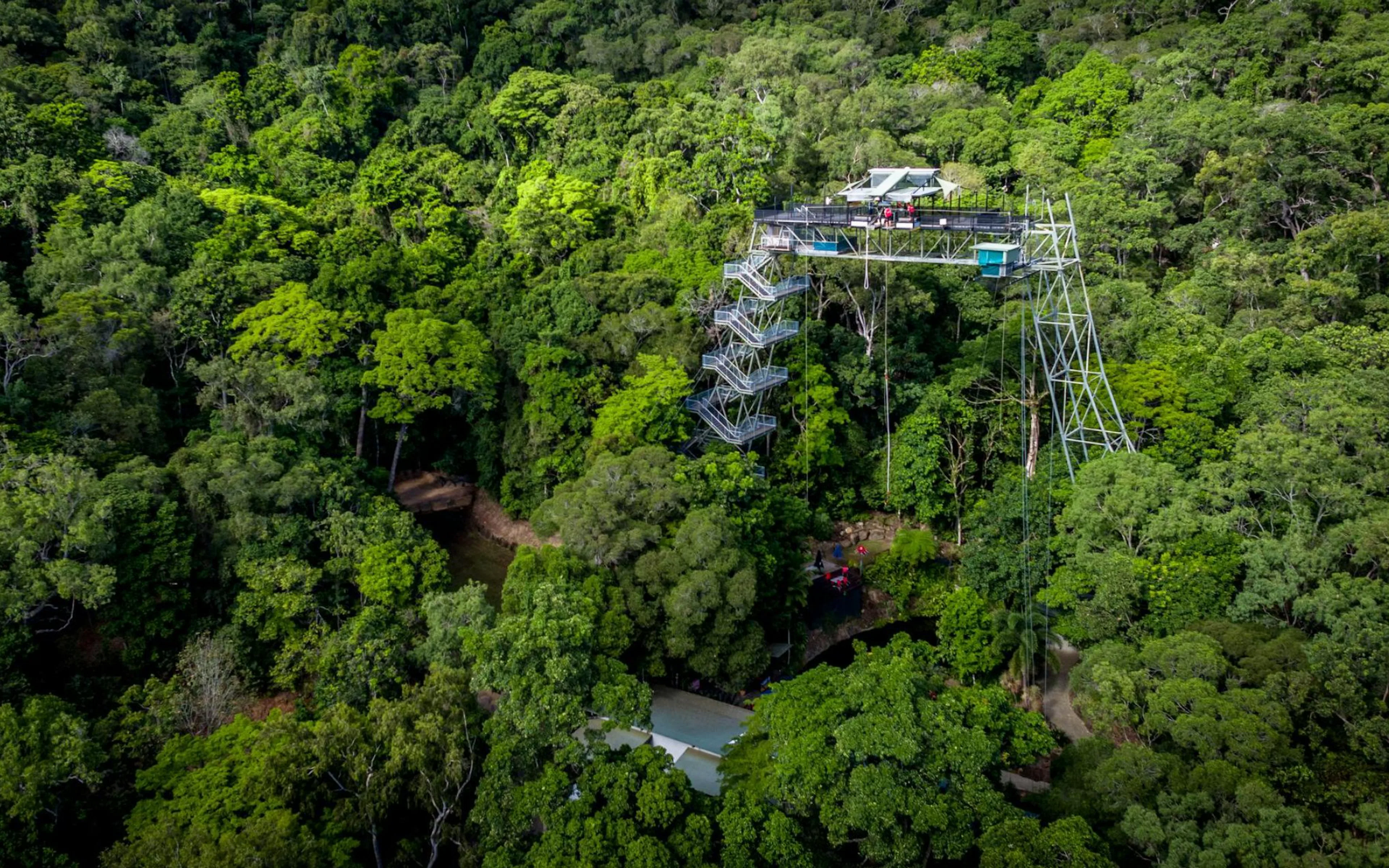 Skypark Cairns tower surrounded by lush rainforest, featuring a bungee jumping platform.