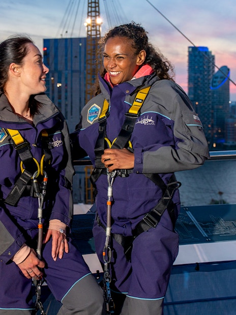 Guests enjoying the O2 rooftop experience at twilight with city skyline in the background.