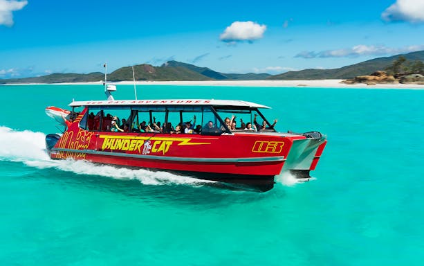 Thundercat catamaran sailing through Whitsundays' turquoise waters on a full-day tour.