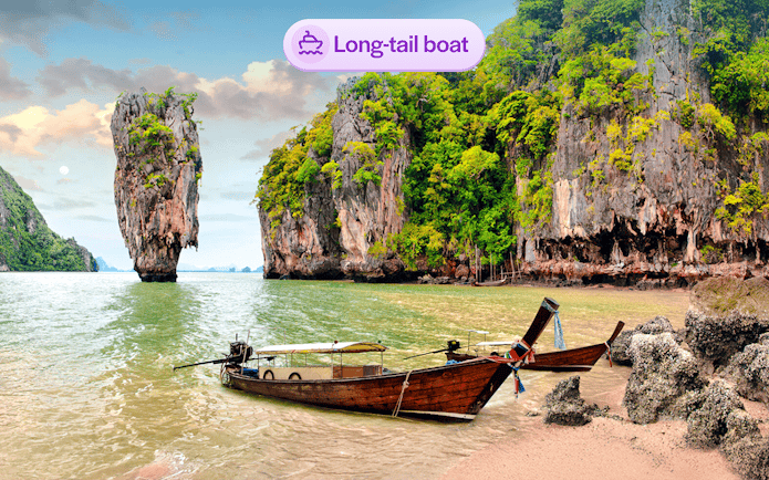 Long-tail boat near limestone cliffs at James Bond Island, Thailand.